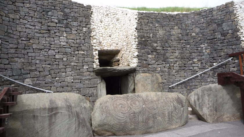 De ingang tot de tombe wordt afgeschermd door grote stenen met spiralen en zigzagvormen.